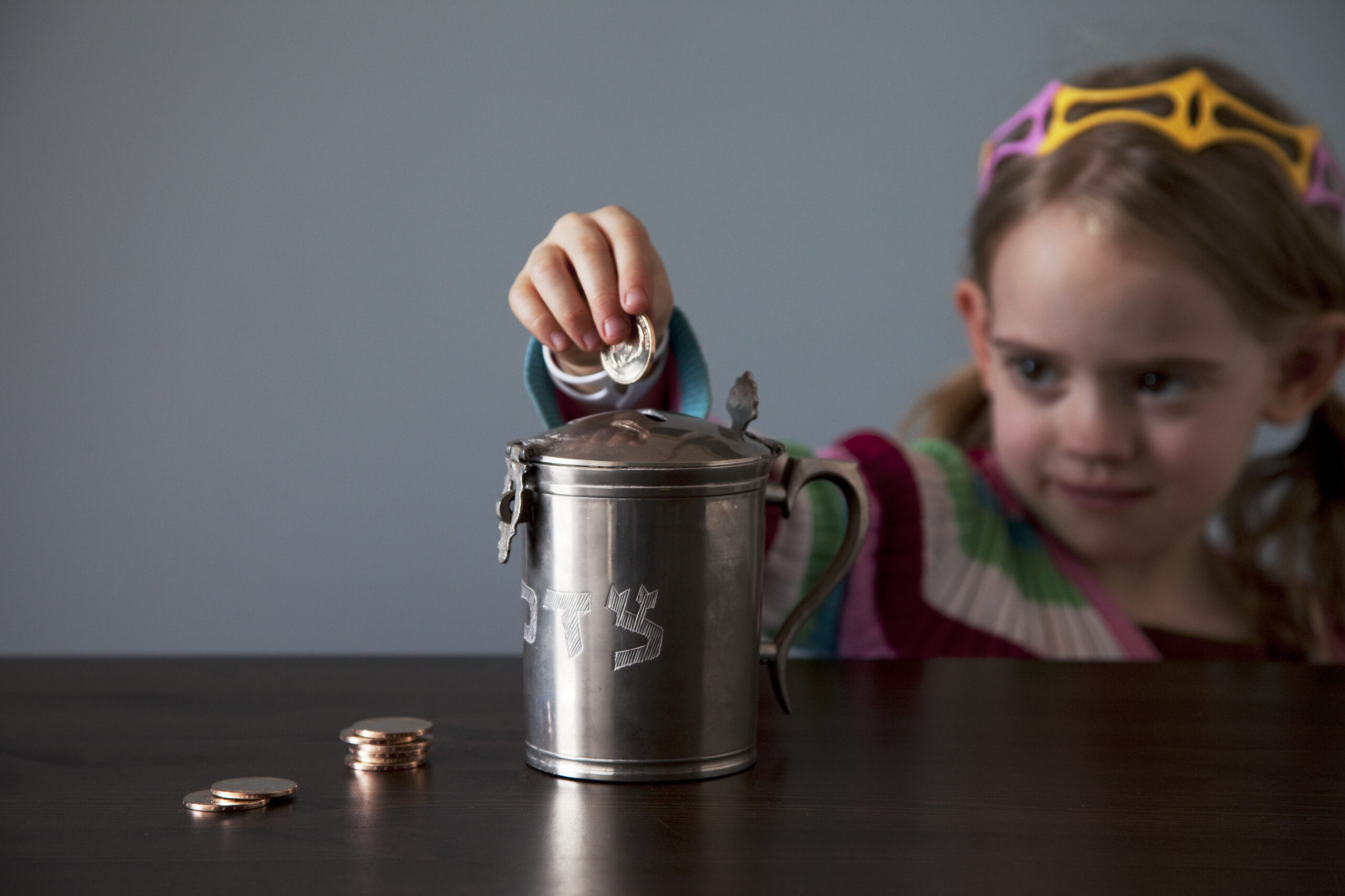 Girl Drops Coins into Tzedakah JarCopyrightJFNA